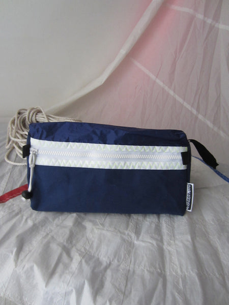 Trianglar shaped storage case for toiletries, and essentials for travel. Sits solidly on surface. Wrist strap made of webbing and heavy duty zip. Lined.