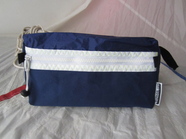 Trianglar shaped storage case for toiletries, and essentials for travel. Sits solidly on surface. Wrist strap made of webbing and heavy duty zip. Lined.