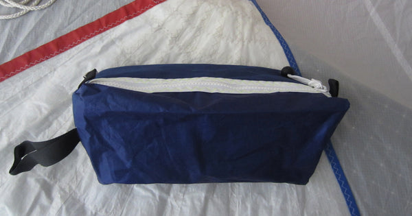 Trianglar shaped storage case for toiletries, and essentials for travel. Sits solidly on surface. Wrist strap made of webbing and heavy duty zip. Lined.